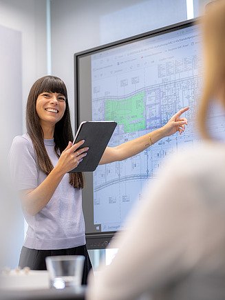 A photographic technician in the office looks at the plan