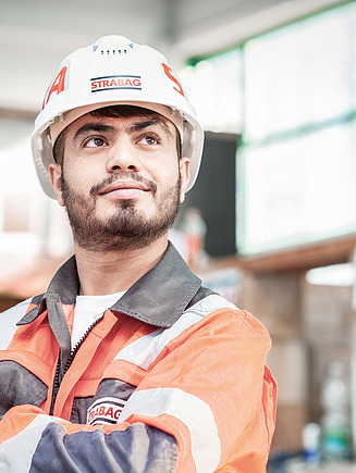 Photo: A man wearing a helmet and with his fists clenched looks up to the right